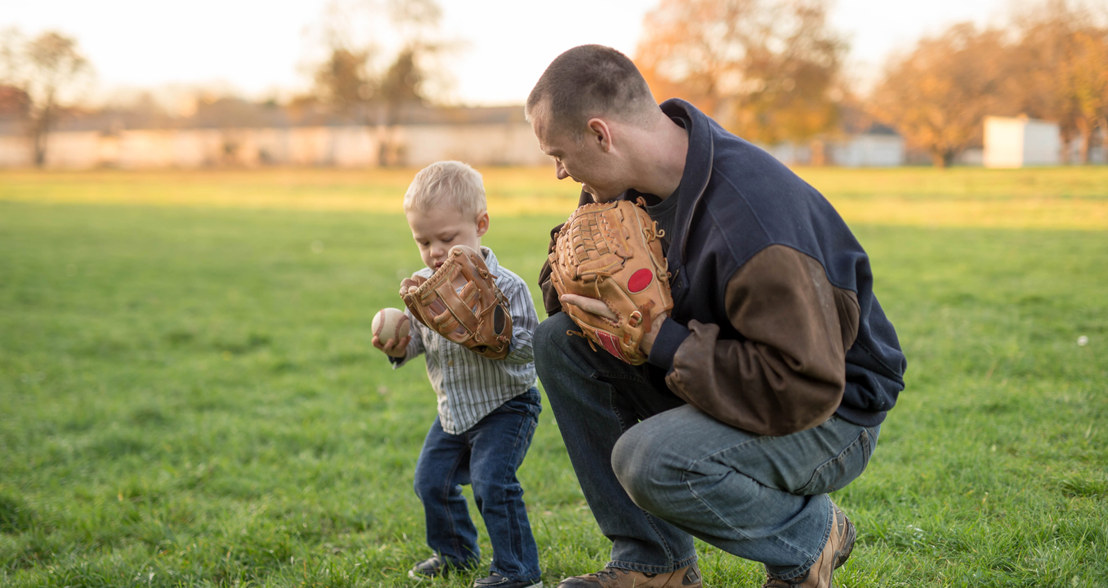 father and child playing baseball